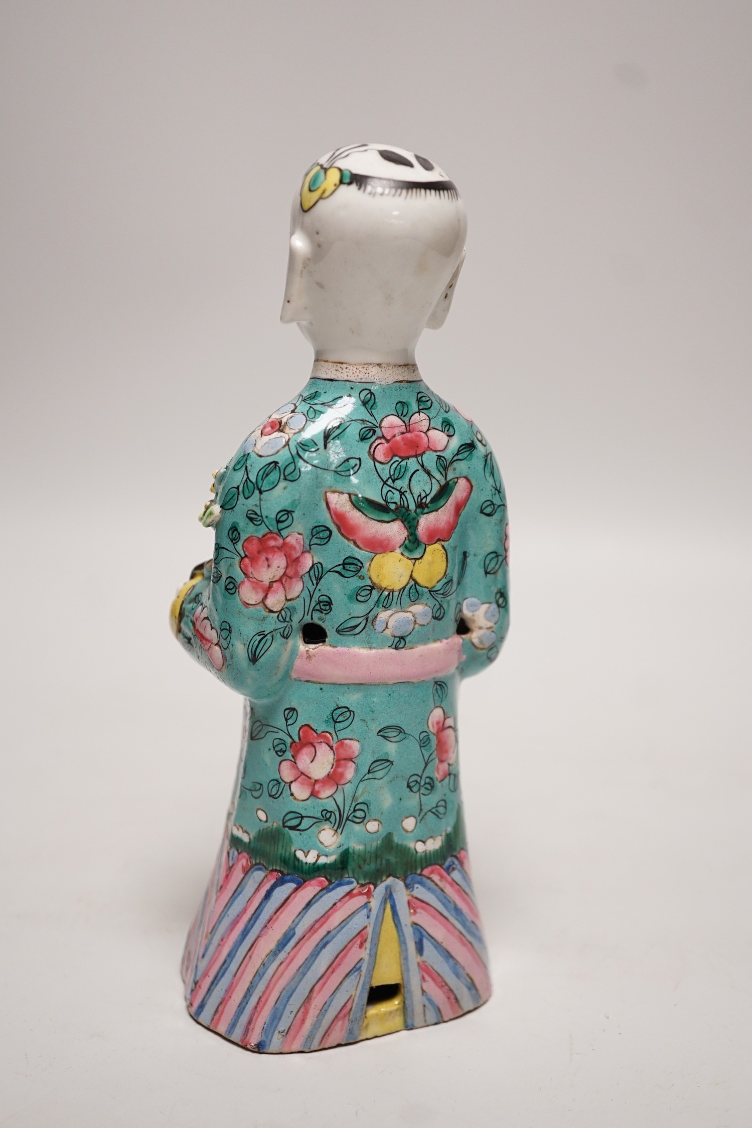 An early 19th century Chinese enamelled porcelain figure of a boy holding a cat and a sprig of prunus, 20cm